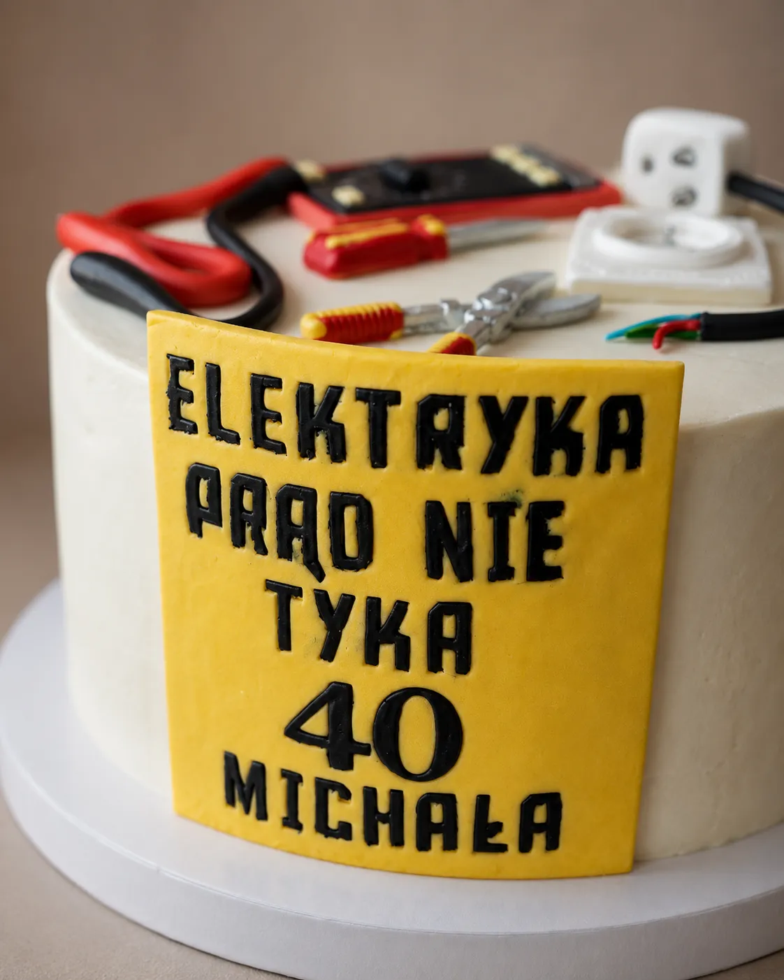 Zbliżenie na żółtą tabliczkę z napisem Elektryka prąd nie tyka 40 Michała